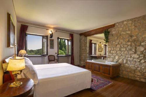 a bedroom with a large bed and a bath tub at Villa Terrarossa with Pool in the Vineyard in Mezzane di Sotto