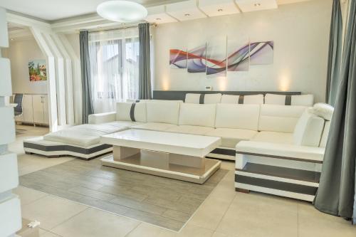 a living room with a white couch and a table at Luxusní vila Serenity 15 min od Prahy in Beroun