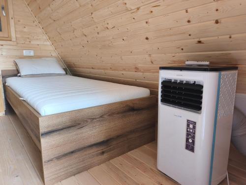 a small room with a bed and an air conditioner at Pr' Končovc - wooden tent in Kranj