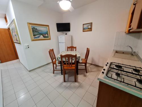 a kitchen with a table and chairs and a refrigerator at Residence Olimpia in Peschici