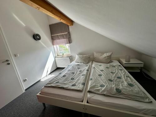 a small bedroom with a bed in a attic at Ferienwohnung Munchen in Vaterstetten