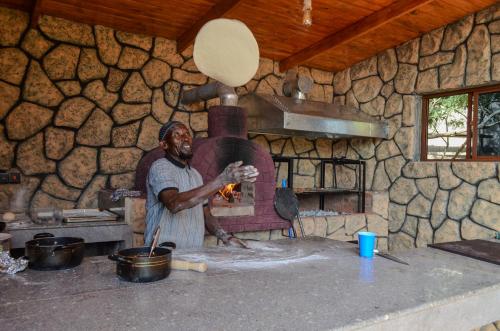 a man standing in front of a brick oven at Maasai ecoLodge in Karatu