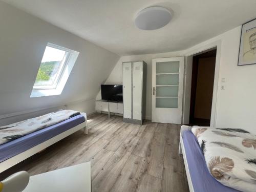 a bedroom with two beds and a tv in it at Schönste Aussicht in Königstein an der Elbe