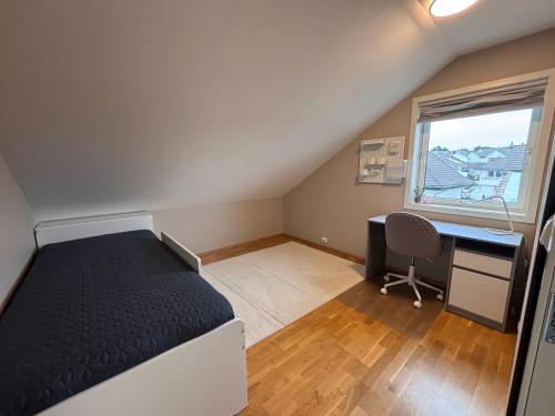 a bedroom with a bed and a desk and a window at Cozy Scandinavian Retreat in Sola