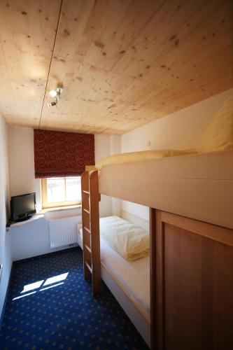 two bunk beds in a room with a television at Dorfappartements Söll in Söll
