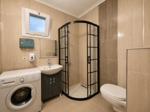 a bathroom with a toilet a sink and a washing machine at Pasha Residence in Trabzon