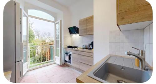 a kitchen with a sink and a large window at Authentic Residence from 1792 - Caujac in Caujac