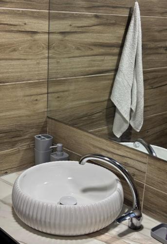 a white sink in a bathroom with wooden walls at LiLo s Villa in Ferizaj
