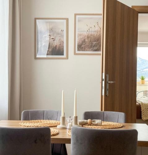 a dining room table with two candles and two chairs at Askana in Białka Tatrzańska