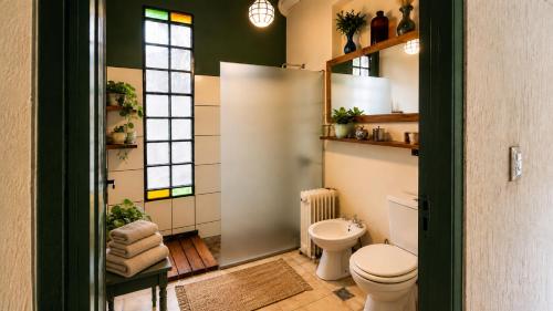 a bathroom with a toilet and a shower and window at Las Pircas, casa de campo in Ciudad Lujan de Cuyo