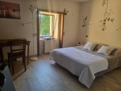 a bedroom with a bed and a desk and a window at le moulin d'âne à niort in Niort
