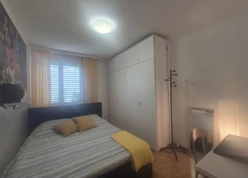 a bedroom with a bed with two pillows and a cabinet at Paradise Jungle in Paradiso