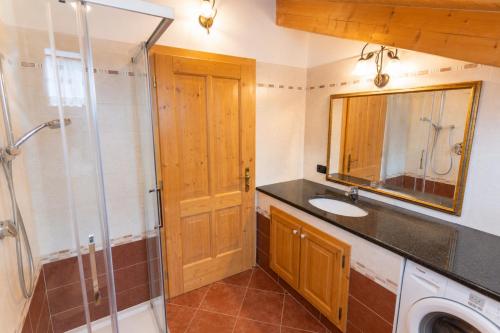 a bathroom with a sink and a shower and a mirror at Rossetti Big by AMA Val di Fassa in Pozza di Fassa