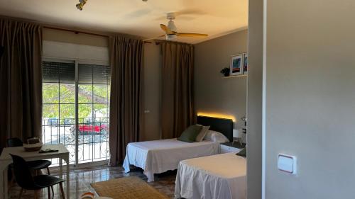 a hotel room with two beds and a balcony at Hotel Restaurant Europeu in Montmeló