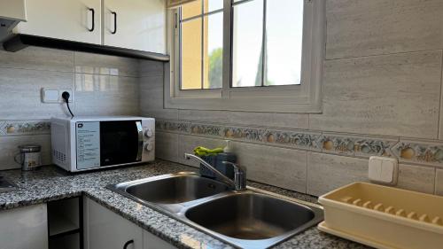 a kitchen with a sink and a microwave at Hotel Restaurant Europeu in Montmeló