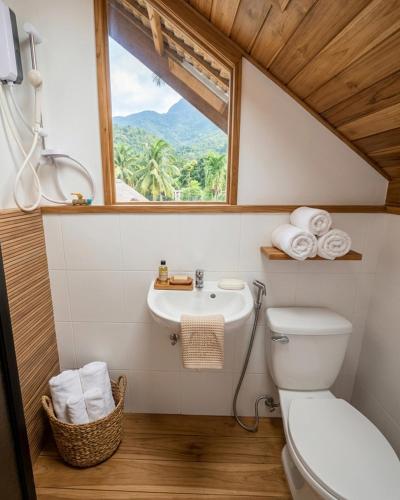a bathroom with a toilet and a sink and a window at D Mountain Beach Resort - Beachfront in Puerto Galera