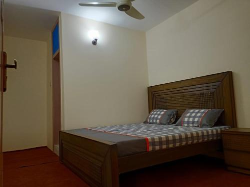 a bed in a bedroom with a ceiling fan at Royal hotel jaglot gilgit in Gilgit