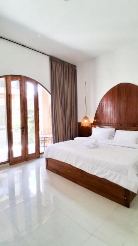 a bedroom with a large bed with a wooden headboard at Heritage Stay in Bingin Beach