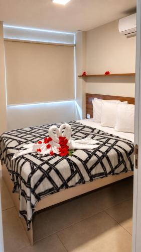 a bed with two teddy bears sitting on it at Apartamento com Piscina Rooftop e Hidro perto do Centro e da Praia, Porto Blue Porto de Galinhas in Porto De Galinhas