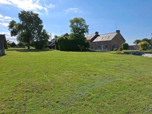 a large grassy field in front of a house at Emplacement camping car terrain privé cher l'habitant à Plœuc-L'Hermitage in Pourhon