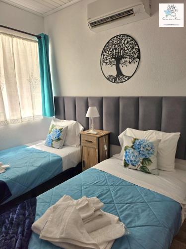 a bedroom with two beds and a tree picture on the wall at Casa da Mica in Faja Grande