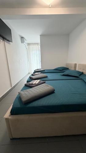 a room with a bed with blue sheets and pillows at Belvedere Costinesti in Costinesti