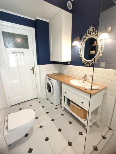 a bathroom with a toilet sink and a washing machine at Kamienica u Artystów in Sopot