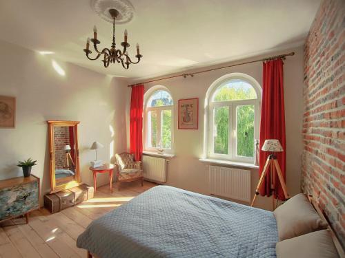 a bedroom with a bed and two windows at Kamienica u Artystów in Sopot