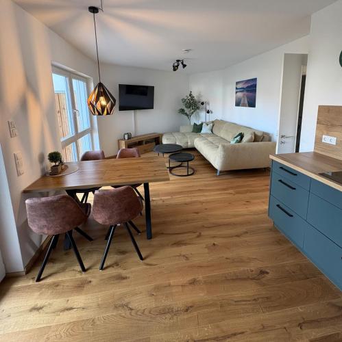 a kitchen and living room with a wooden table at Ferienwohnung "Große Auszeit" in Schongau