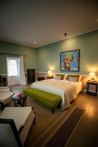a large bedroom with a large bed with a green couch at Belo Monte - Principe Collection in Santo António