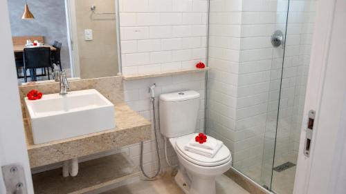 a bathroom with a toilet and a sink at Apartamento com Piscina Rooftop e Hidro perto do Centro e da Praia, Porto Blue Porto de Galinhas in Porto De Galinhas