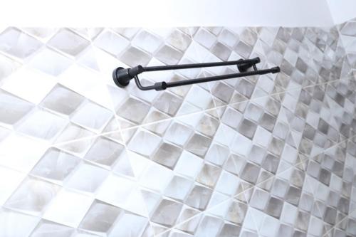 a towel rack in a bathroom with white tiles at KilimaVista Homes 1 bedroom apartment in Kimana