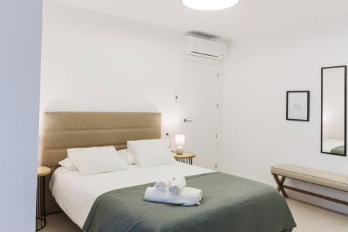 a bedroom with a bed with two towels on it at Royar Apartamentos in Jaén