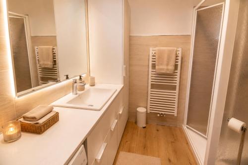 a white bathroom with a sink and a shower at Appartamenti Col Rodella by AMA Val di Fassa in Campitello di Fassa