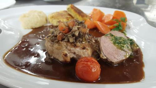a plate of food with meat and gravy and vegetables at Hotel 3 Könige in Oberwolfach