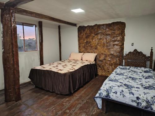 a bedroom with two beds and a window at Alpes Goianos - Suítes in Cavalcante