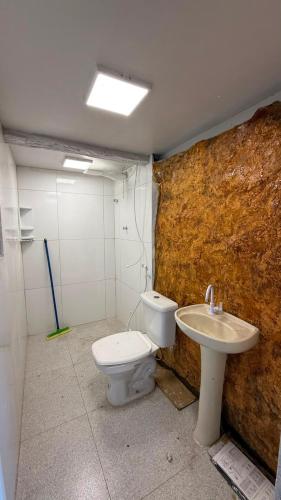 a bathroom with a toilet and a sink at Alpes Goianos - Suítes in Cavalcante