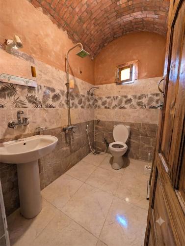 a bathroom with a sink and a toilet at Mezorin Farm & Hot Spring - Peaceful Eco-Retreat & Private Stay in Siwa