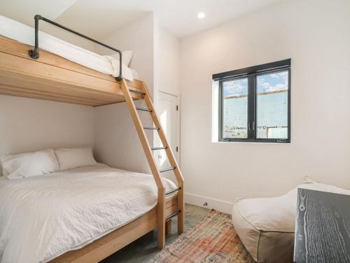 a bedroom with a bunk bed and a window at Black Arrow Chalet in Courtenay