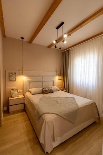 a bedroom with a large bed with lights on it at Avila Casa in Podgorica