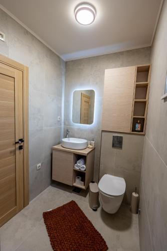 a bathroom with a sink and a toilet and a mirror at Avila Casa in Podgorica