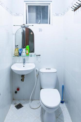a white bathroom with a toilet and a sink at Lumi living hostel in Ho Chi Minh City