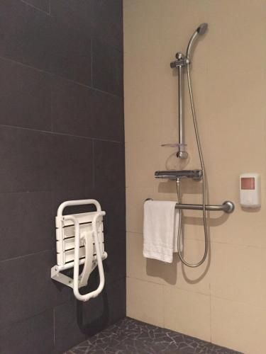 a bathroom with a shower and a towel rack at Brit Hotel Golfhotel Saint Samson in Pleumeur-Bodou