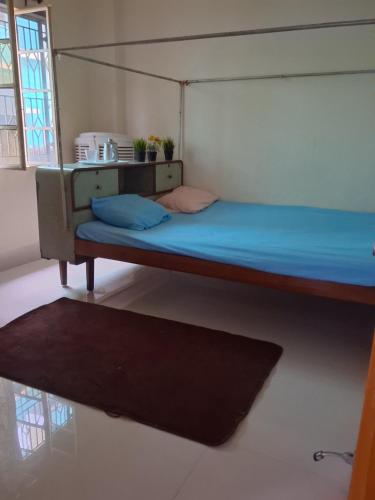 a bedroom with a bunk bed with blue sheets and a rug at Paras home in Deoghar