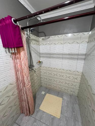 a shower with a pink shower curtain in a bathroom at Rusty Rock Beach Resort & Spa in Mwanza
