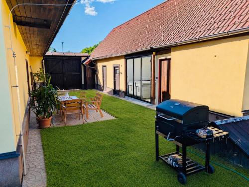 a backyard with a grill on the grass at Škorničkův statek - chalupa Andělka s wellness za příplatek in Hamr