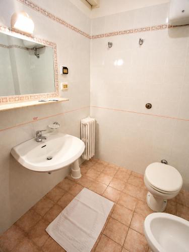 a bathroom with a sink and a toilet and a mirror at Hotel Viola in Gaeta