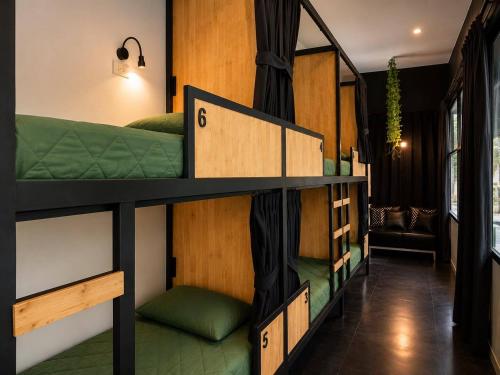 a room with four bunk beds in a room at Smith & Appy Backpackers Hostel in Nathon Bay