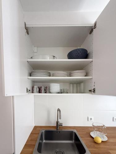 a kitchen with a sink and white cabinets at Casa Bossa Nova in Fundão