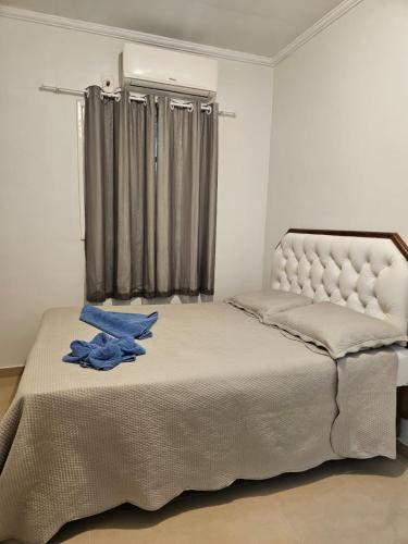a bedroom with a bed with a blue shirt on it at Casa de Charles in Piranhas